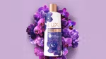 A photo of LUX Magical Orchid shower gel. White bottle surrounded by purple orchid flowers.