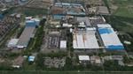 An aerial view of Unilever's Gandhidham factory in India. Blue, grey and white rooftops surrounded by green fields.