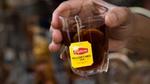 A hand holding a cup of Lipton's tea