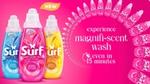 Three Surf Magnifi-scent wash bottles on the left and text that reads ‘experience magnifi-scent wash every 15 minutes' on the right. The text is wrapped around by Surf Magnifi-scent wash bottles and against a pink background.