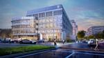 Modern glass-and-steel office building with Unilever logo at dusk, lit interior visible, pedestrians and cars outside on a city street.