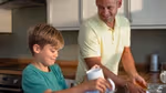 Father and young son in a kitchen doing the washing up together