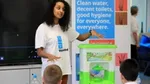 Woman explaining WaterAid’s work to school children