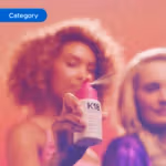 Hand holding a K18 hair product spray bottle with mist visible, set against a warm pink background. The image is tagged ‘Category’.