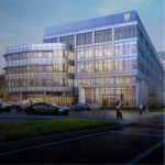 Modern multi-storey office building with a glass façade and illuminated interior at dusk, showing people inside and outside near the entrance, cars on a wet street, and a visible Unilever logo at the top.