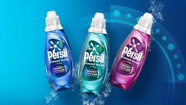 Three Persil Wonder Wash bottles in blue, teal, and purple displayed against a blue background with water splash effects.