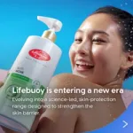 A bottle of Lifebuoy Anti Acne body wash is held in the foreground against a blue background, with water droplets visible around a person’s shoulder. Text on the image reads: ‘Lifebuoy is entering a new era – evolving into a science-led, skin-protection range designed to strengthen the skin barrier.