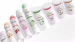 A line-up of Dove spray and stick deodorants with pink, light green, purple and orange lids.