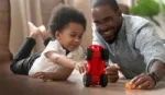 Boy and father playing with toy car